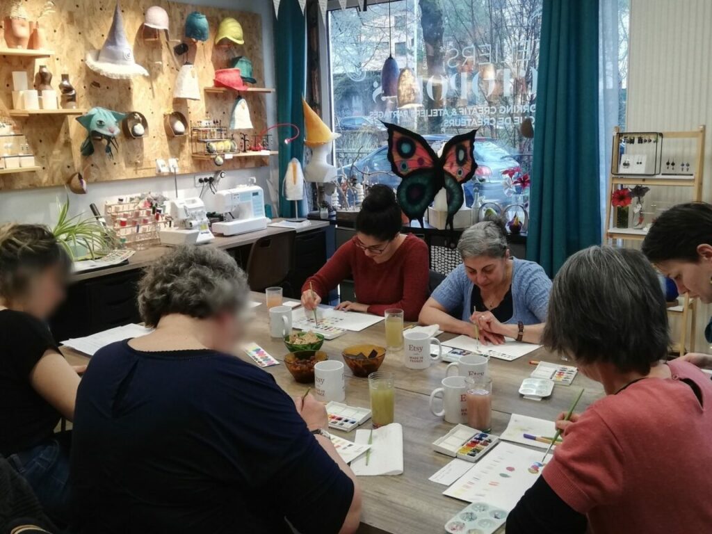 Atelier aquarelle, des personnes sont autour d'une table et dessinent